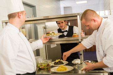 Professional kitchen cook prepare meal give waiter