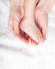 Mother gently hold baby's leg in her hands