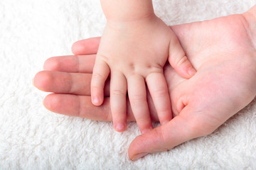 Mother's hand holding baby's hand