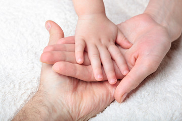 Closeup of baby, mother and father hands
