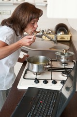 Multitasking woman - cooking meal and working