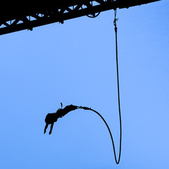 Bungee jumper against blue sky