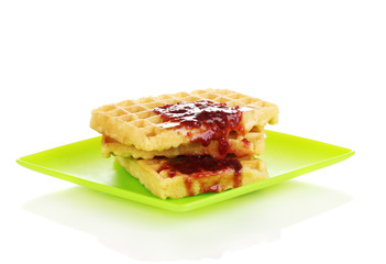 Tasty waffles with jam on plate isolated on white