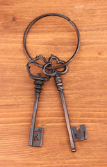 a bunch of antique keys on wooden background