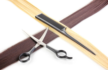 Shiny blond and brown hair with hair cutting shears and comb