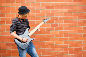 teen boy playing guitar outdoors