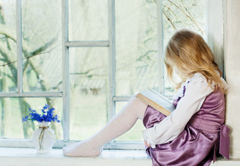 little girl reading book indoor