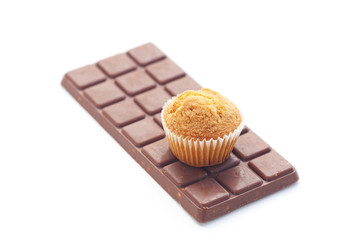 bar of dark chocolate and muffin isolated on white