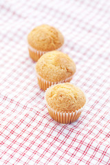 three muffins on plaid fabric