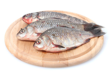 Fresh fishes on wooden cutting board isolated on white