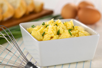 Scrambled eggs with green onion in bowl with beater