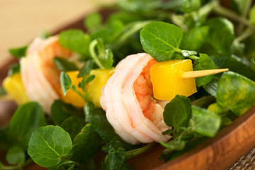 Shrimp, mango and avocado on skewer with watercress