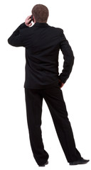 Rear view of business man in black suit  talking on mobile phone