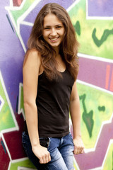 Style teen girl near graffiti background.