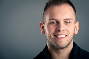 Fototapeta premium Young happy boy close up portrait against grey background