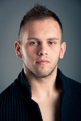 Fototapeta premium Young boy close up portrait against grey background.