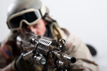 Soldier with rifle against white background.