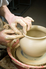 hands of a potter, creating an earthen jar on the circle