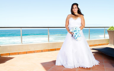 Fototapeta na wymiar beautiful bride with bouquet and sea view