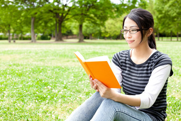 Obraz premium asian woman reading a book in the park