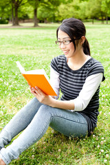 Obraz premium asian woman reading a book in the park