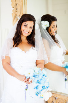 beautiful young bride standing next to mirror