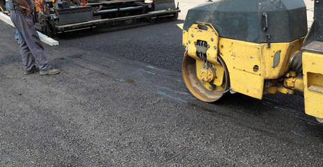 Roadwork road roller at hot asphalt