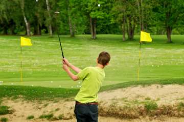 Golfspieler beim Abschlag im Bunker