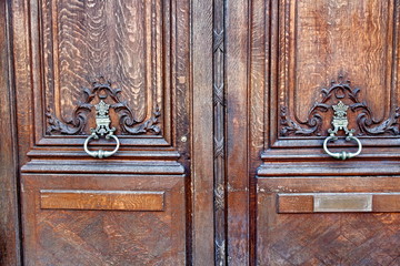Porte cochère en bois avec heurtoirs de bronze.