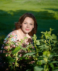 The young woman sits in a green grass