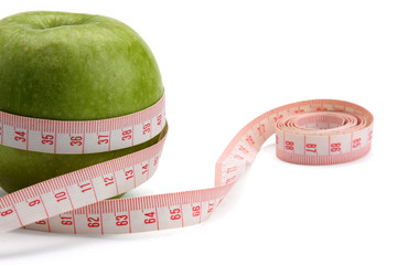 A green apple and a measuring tape isolated on white background