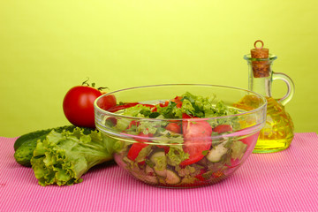 Fresh salad with tomatoes and cucumbers on green background