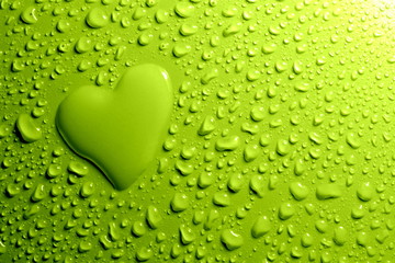 Water drops and  heart shape on green background