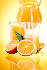 Juice to pour from pitcher, Oranges with leaves on yellow backgr