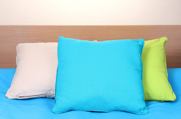 bright pillows on bed on beige background