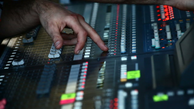 Man in sound studio working with sound mixer console