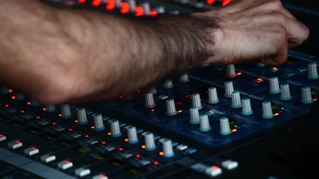 Man in sound studio working with sound mixer console