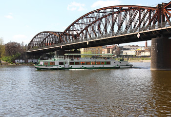 Vltava river in Prague with boats and railway bridge