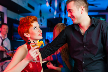 Junges Paar in einer Bar oder Club trinkt Cocktails