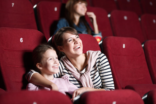 Loughing mother and daughter at the cinema