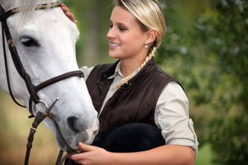 Young lady stroking her horse