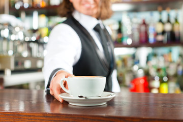 Barista bereitet Cappuccino zu in seinem Cafe
