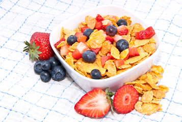 Cornflakes with fresh fruits on a tablecloth