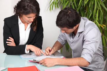 Businesswoman helping her client fill in paperwork