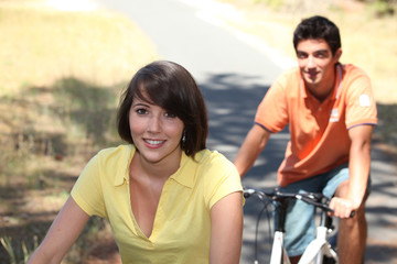 Young couple riding bikes in the country