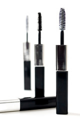 Isolated black mascara with brush laying on white background