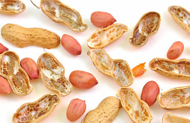 split pods of peanuts scattered on white