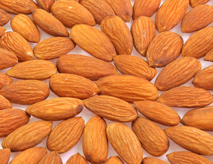 close up of almonds arranged on white background
