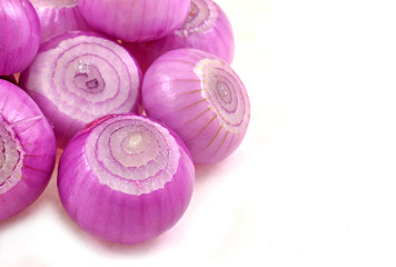 whole unscaled pink onions arranged on white background