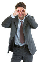 Modern businessman looking through binoculars shaped hands